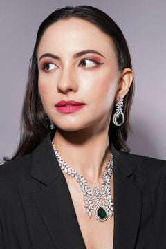 Woman wearing a luxurious necklace and earrings against a neutral background