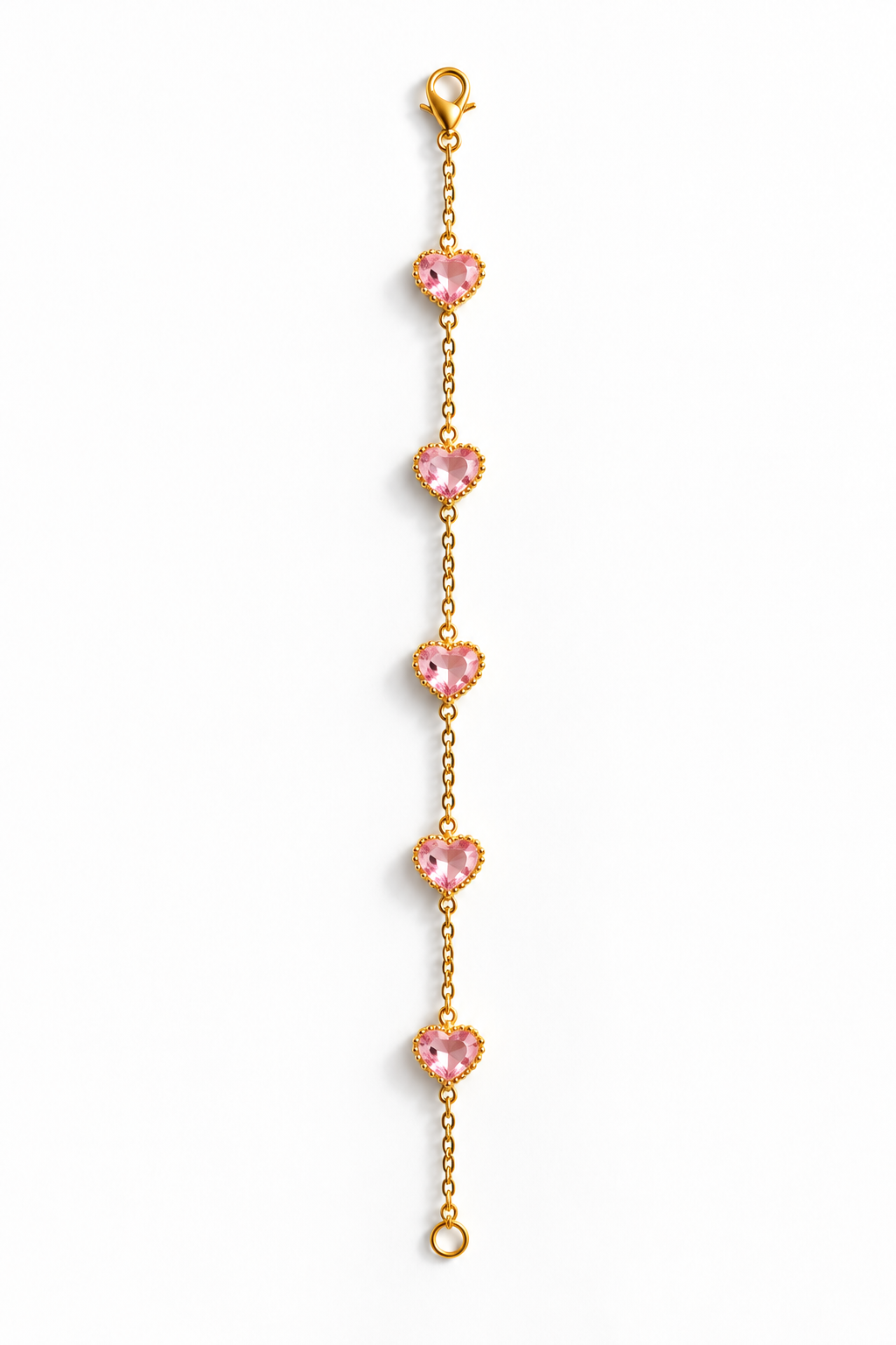 A delicate gold chain bracelet featuring five evenly spaced, heart-shaped pink gemstones, displayed vertically on a clean white background.