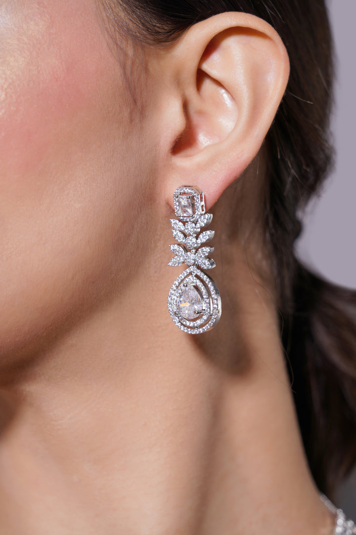 Close-up of a diamond earring on an ear with a neutral background