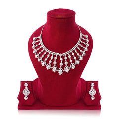 Silver necklace and earrings set on a red velvet stand with a white background