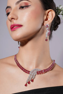 Woman wearing a red and silver jewelry set with a gray background