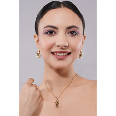 Woman wearing gold earrings and necklace against a gray background