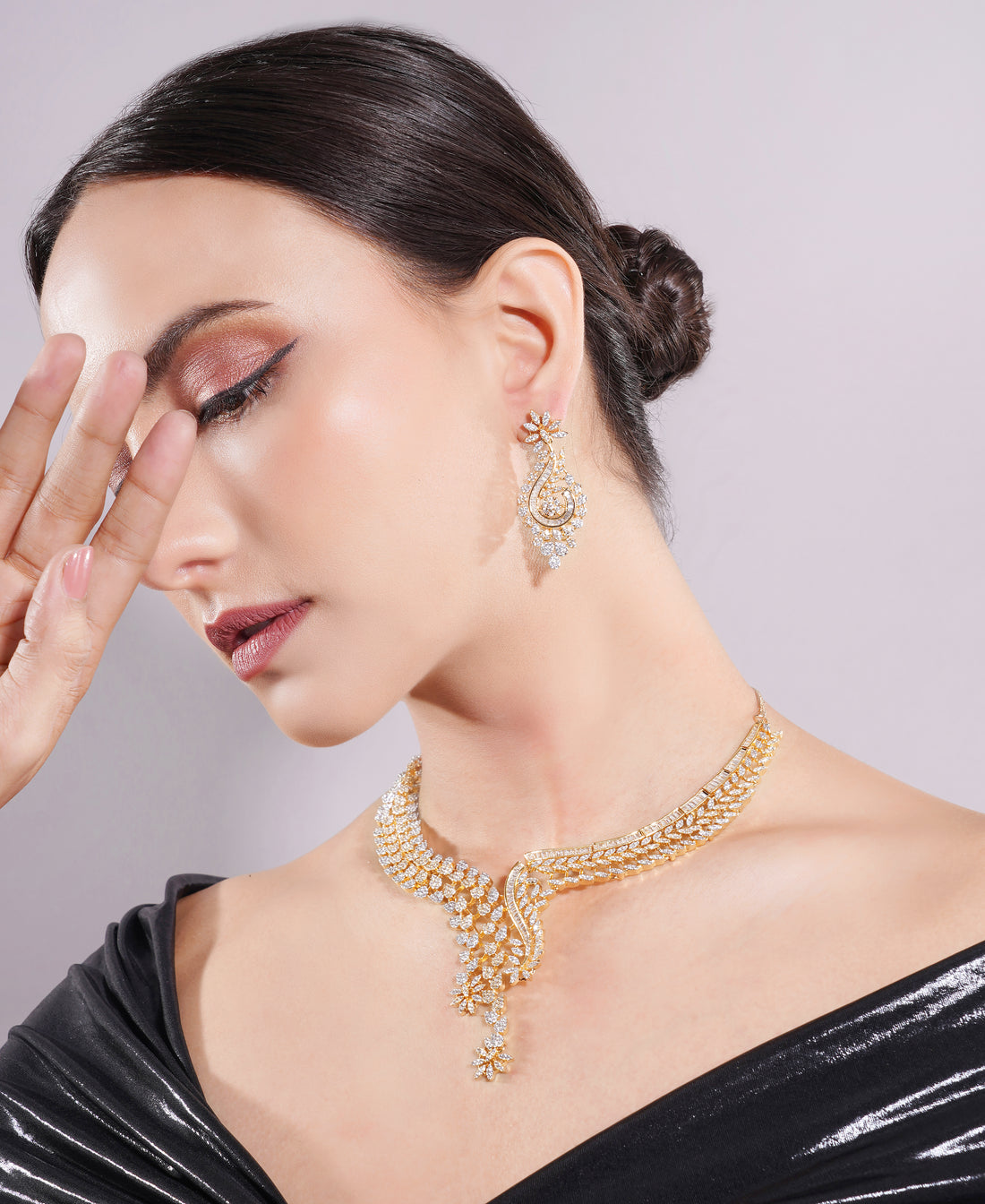 Woman wearing gold jewelry with a plain background