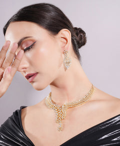 Woman wearing gold jewelry with a plain background