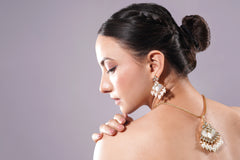 Woman wearing elegant earrings with a neutral background