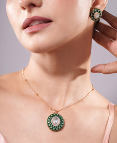 Close-up of a woman wearing a green gemstone necklace and earrings against a neutral background