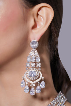 Close-up of a woman wearing a sparkling diamond earring against a neutral background