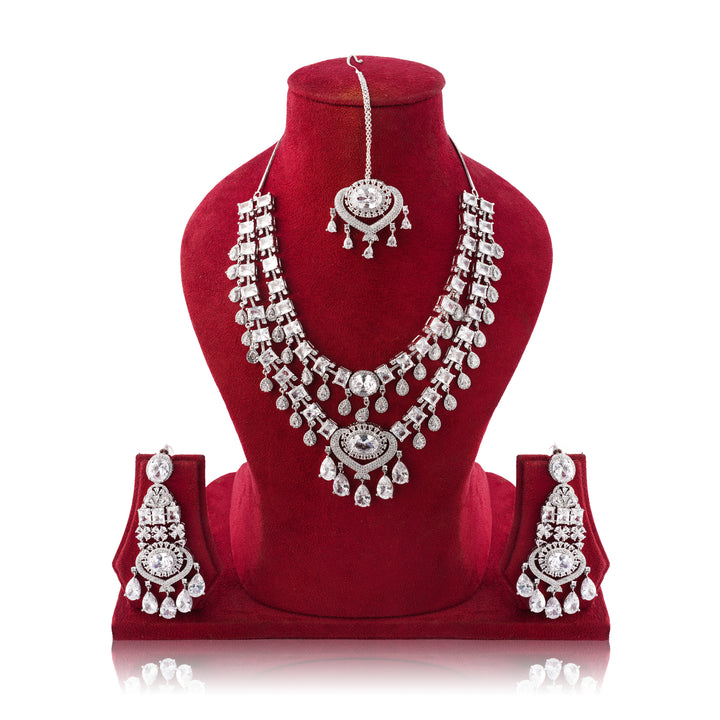 Silver jewelry set with necklace, earrings, and headpiece on a red velvet stand.