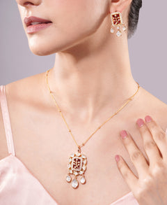 Close-up of a woman wearing a gold necklace and earrings on a light gray background
