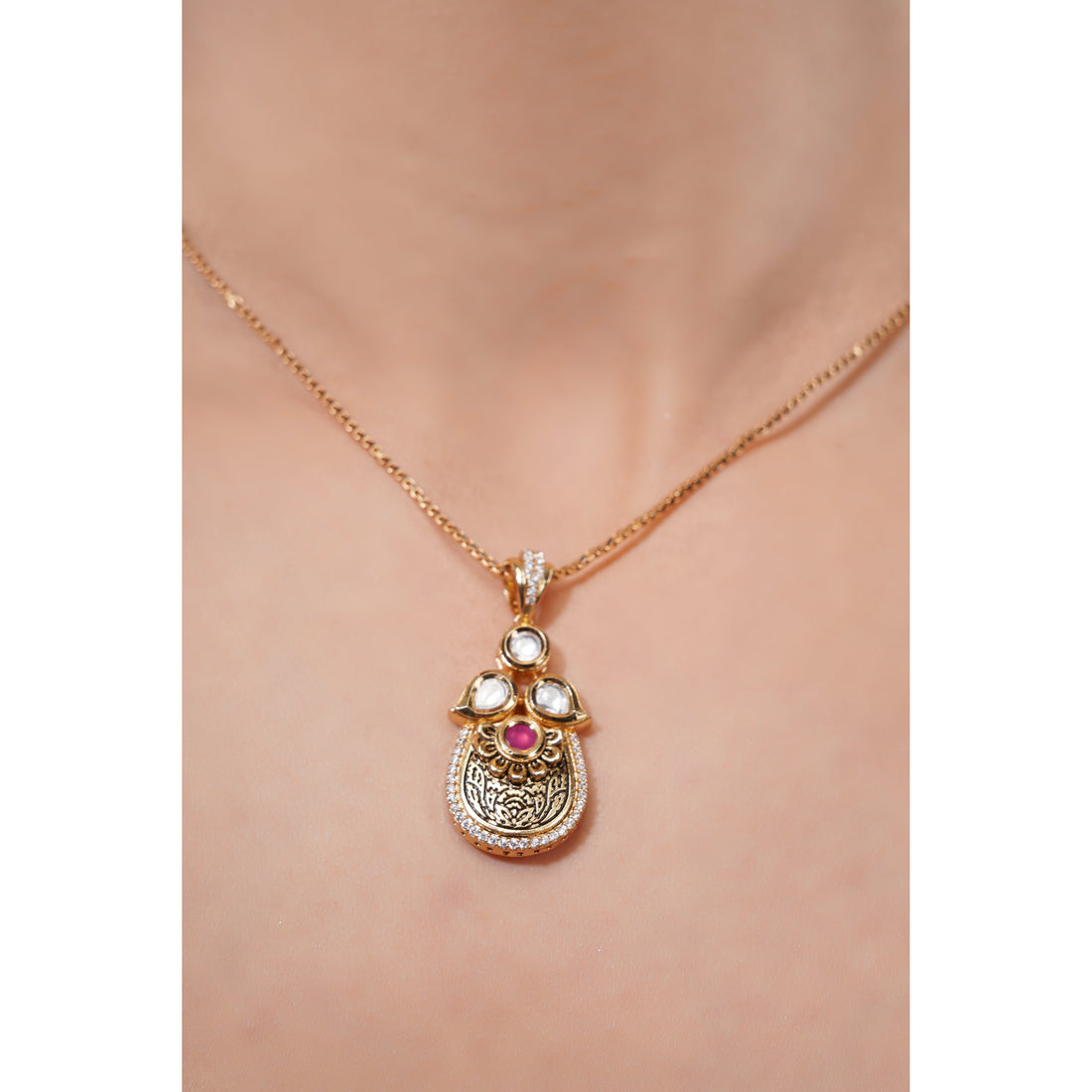 Gold necklace with a pendant on a mannequin
